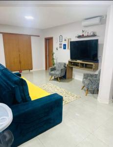 a living room with a blue couch and a flat screen tv at Casa de Hóspedes Kipper in São Gabriel +16 photos