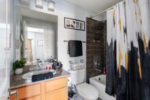 a bathroom with a sink and a toilet and a tub at Fireside Double Kings Midtown Luxe Suite in Houston +31 photos