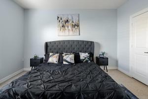 a bedroom with a large black bed with pillows at Fireside Double Kings Midtown Luxe Suite in Houston
