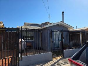 a fence with a dog sitting inside of it at Casa Flor del aire in La Serena