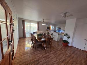 a dining room and kitchen with a table and chairs at Casa Flor del aire in La Serena