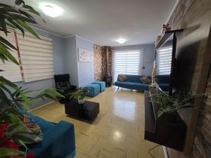 a living room with blue couches and a flat screen tv at Casa Flor del aire in La Serena
