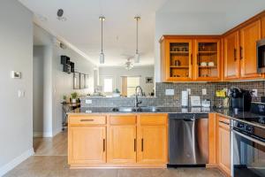 a kitchen with wooden cabinets and a sink at Fireside Double Kings Midtown Luxe Suite in Houston