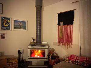 a living room with a stove with a fire in it at La Sirena, Venus Bay in Venus Bay