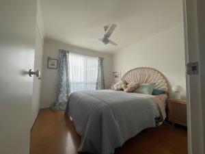 a bedroom with a bed and a ceiling fan at La Sirena, Venus Bay in Venus Bay