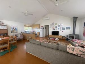 a living room with two couches and a table and a kitchen at La Sirena, Venus Bay in Venus Bay