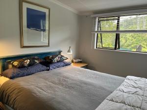 a bedroom with a large bed and a window at Portobello Bach Double Cove in Lochmara Bay