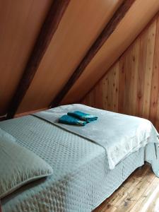 a white bed in a room with wooden walls at Chale Primavera in Benedito Novo