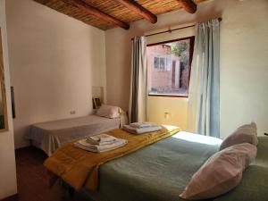 two beds in a room with a window at Vivir en Maimará in Maimará