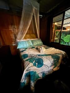 een bed in een kamer met een raam bij Mountain Retreat Refugio de Aves in Turrialba +74 foto's