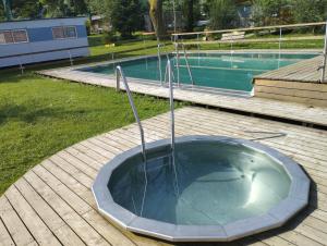 a hot tub in a yard next to a swimming pool at Dobromil - Camp pod kaštany in Morávka +4 photos