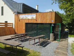 a group of benches sitting outside of a building at Dobromil - Camp pod kaštany in Morávka