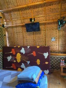a bed in a room with a wall with leaves on it at D Cottage Sabin in Punten