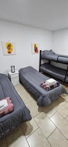 een slaapkamer met 2 bedden en een tegelvloer bij La Juanita in Junín de los Andes