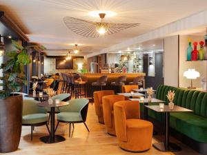 a restaurant with tables and chairs and a bar at Mercure Lyon Centre Plaza République in Lyon