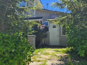 una casa con una porta bianca e un cortile di Apartamento Hortensias del Lago a Puerto Varas