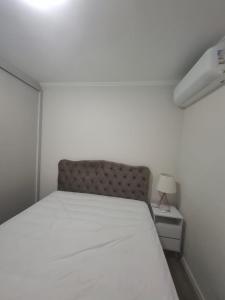 een slaapkamer met een bed en een nachtkastje met een lamp bij Apartamento no Centro em Poços de Caldas in Poços de Caldas