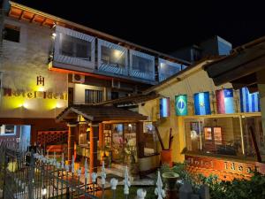 a building with a restaurant with a balcony with lights at Hotel Ideal vcp in Villa Carlos Paz