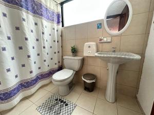 a bathroom with a toilet and a sink and a mirror at Hostal La Estación Quito in Quito +22 photos