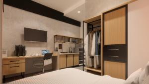 a bedroom with a bed and a desk and a kitchen at Voyager Residence in Semarang