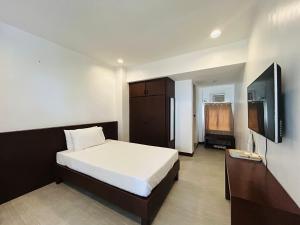 a bedroom with a bed and a flat screen tv at Anaya Villas Resort in Bantayan Island