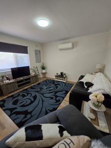 a living room with a couch and a tv at LBarza 1BR CBD Self Contained Apartment in Shepparton