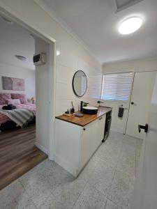 a bathroom with a vanity with a mirror and a bed at LBarza 1BR CBD Self Contained Apartment in Shepparton