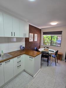 a kitchen with white cabinets and a table and a window at LBarza 1BR CBD Self Contained Apartment in Shepparton