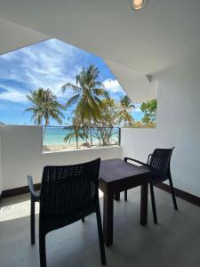 a table and chairs in a room with a view of the beach at Anaya Villas Resort in Bantayan Island +33 photos