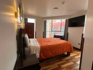 a bedroom with a bed and a large window at Hotel Inka Palace Huayna Ccapac Cusco in Cusco
