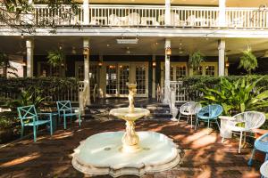 a fountain in the courtyard of a building with chairs at Suites by The Wellborn in Orlando