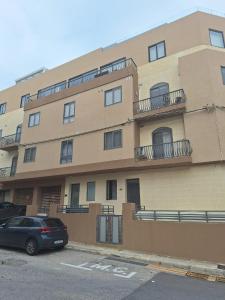 a building with a car parked in front of it at Sandstone Residence St Julian's - 2 bedrooms in Is-Swieqi +7 photos