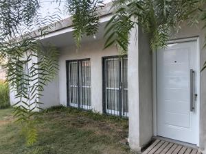 un edificio con una porta bianca e alcuni alberi di casa fin de semana a Paraná