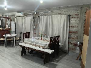 una sala da pranzo con un tavolo e un tavolo e sedie di casa fin de semana a Paraná Altre 10 foto