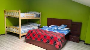 a green room with a bed and bunk beds at Quinta Nallig in Gualaceo +25 photos