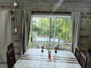 un tavolo con bicchieri da vino e una grande finestra di casa fin de semana a Paraná