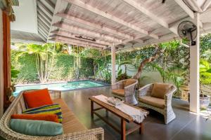 an outdoor patio with chairs and a table and a pool at Alinta Villa 1 - Spacious Sanctuary in Sanur