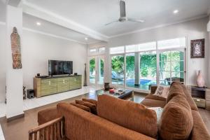 a living room with a couch and a tv at Alinta Villa 1 - Spacious Sanctuary in Sanur