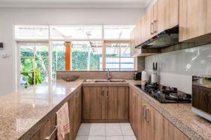 a kitchen with wooden cabinets and a large window at Alinta Villa 1 - Spacious Sanctuary in Sanur