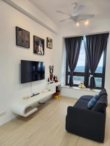 a living room with a black couch and a flat screen tv at Sunway Grid Mickey House 4-5pax, 8mins to Legoland in Iskandar Puteri +19 photos