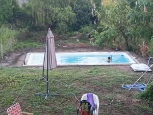 una persona in piscina con ombrellone di casa fin de semana a Paraná