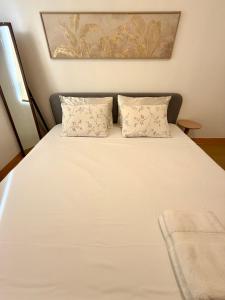 a large white bed with two pillows on it at 1 Bedroom Condo Unit at Centrio Tower in Cagayan de Oro