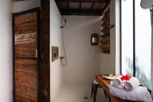 a bathroom with a shower and a wooden table with towels at Villa Rose Barth Location de Chambre in Saint-Louis