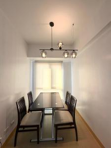 a dining room with a glass table and chairs at 1 Bedroom Condo Unit at Centrio Tower in Cagayan de Oro