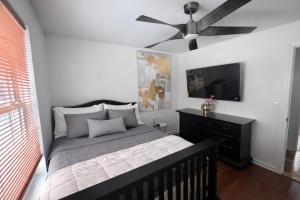 een slaapkamer met een bed en een plafondventilator bij Tremont Hidden Treasure in East Orange