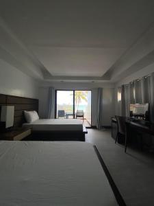 a hotel room with two beds and a window at Anaya Villas Resort in Bantayan Island