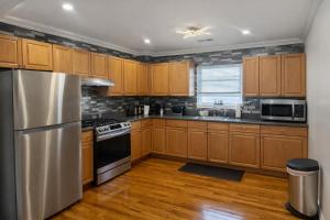 a kitchen with wooden cabinets and a stainless steel refrigerator at Tremont Hidden Treasure in East Orange