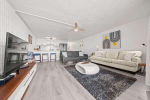 een woonkamer met een bank en een tv bij Beachfront Condo with Ocean View in Hauula