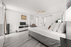 een slaapkamer met een groot bed met een plafondventilator bij Beachfront Condo with Ocean View in Hauula +49 foto's