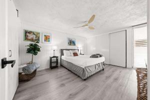 een slaapkamer met een bed en een plafondventilator bij Beachfront Condo with Ocean View in Hauula